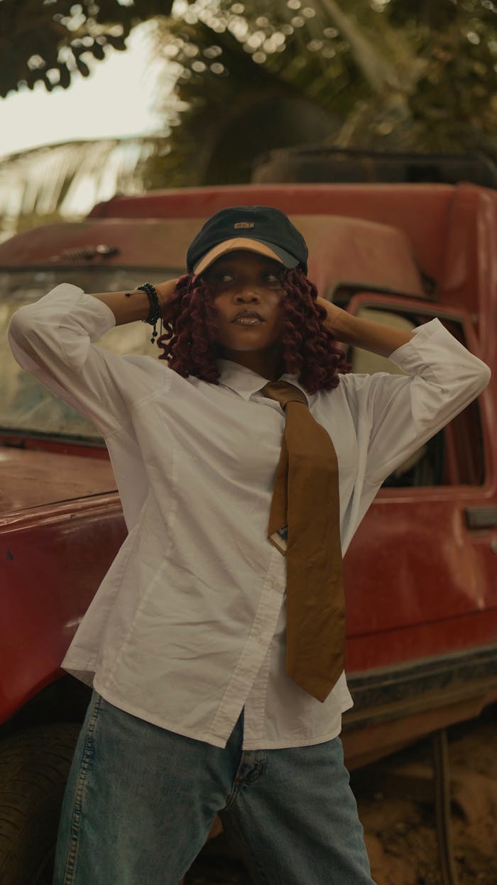 fashionable-woman-posing-outdoors-by-red-car-32595528