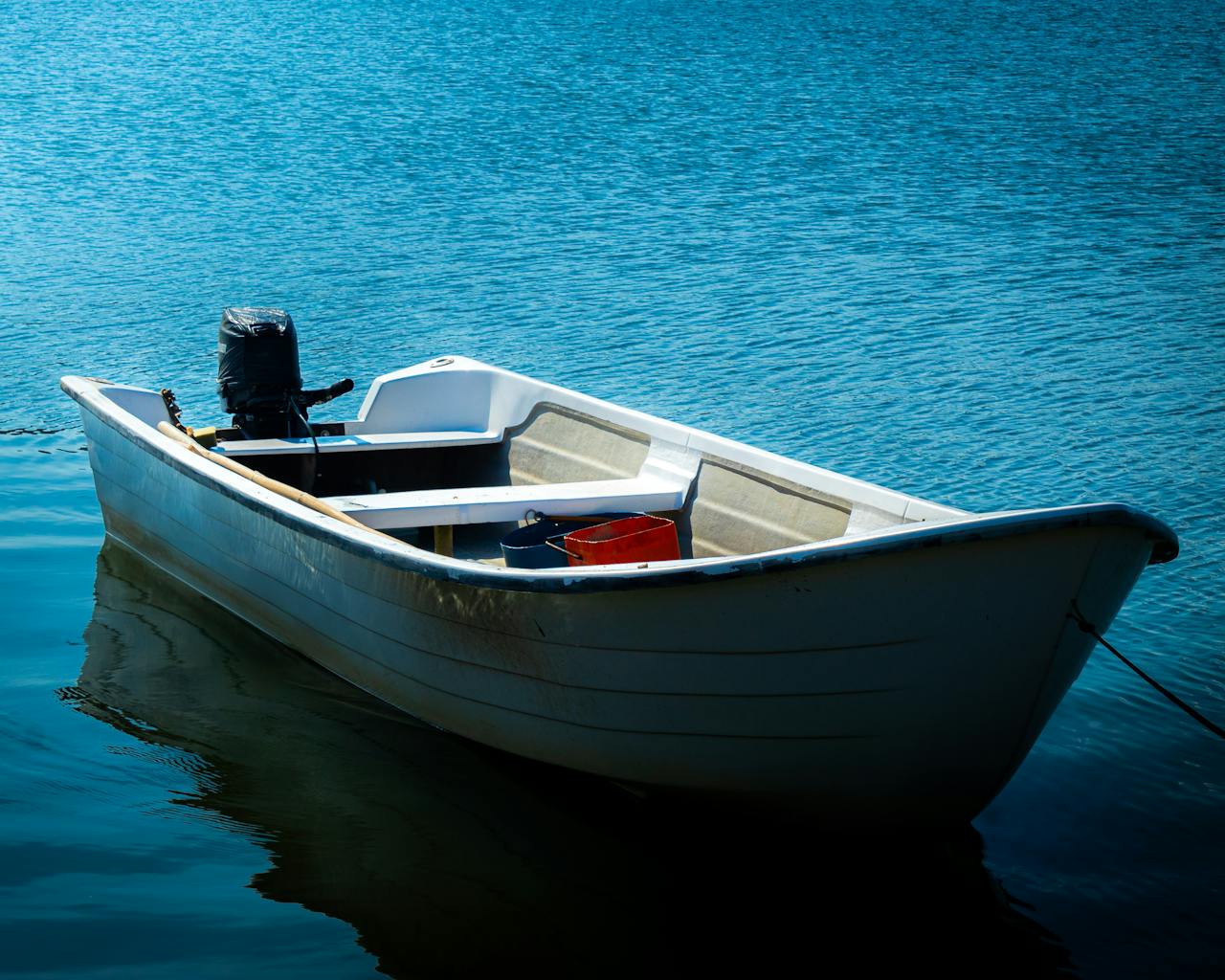 Single white boat gently floating on tranquil blue water in SC, Brazil.